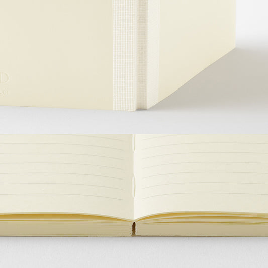 Open notebook with cream-colored pages on a light gray background