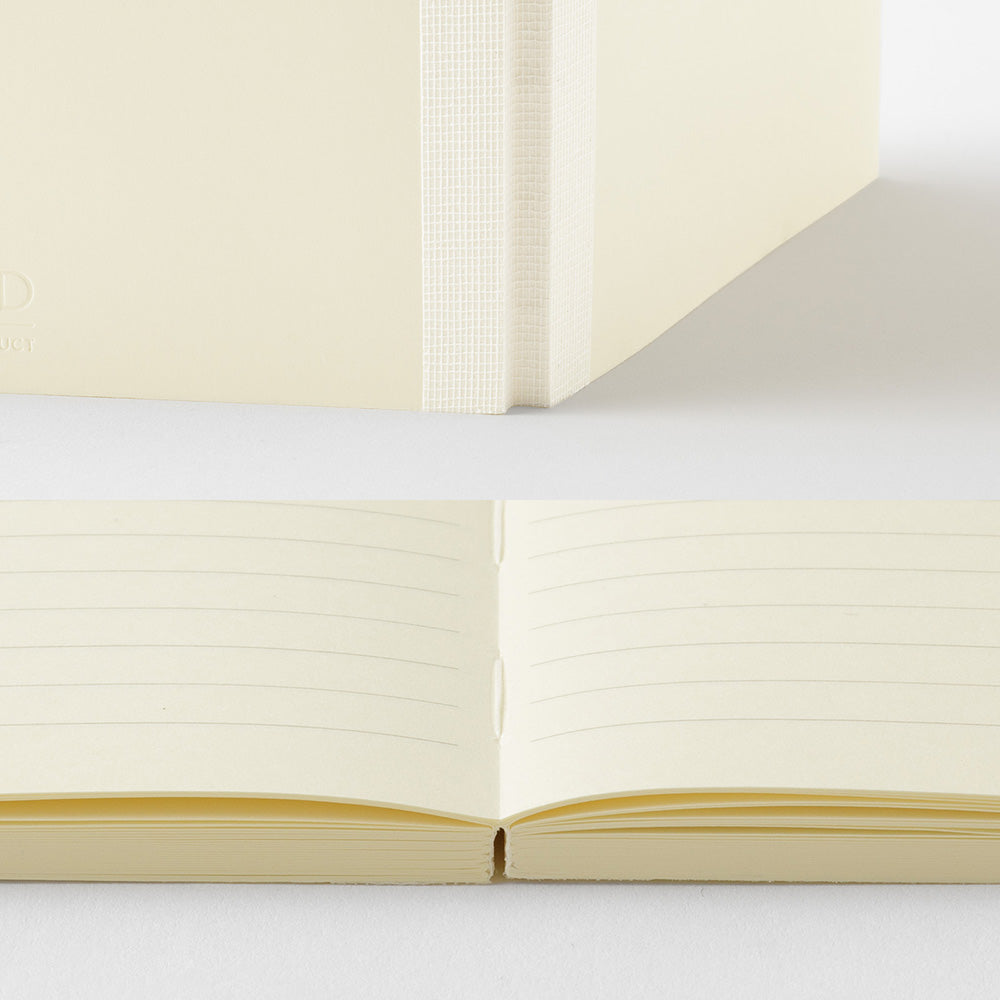 Open notebook with cream-colored pages on a light gray background