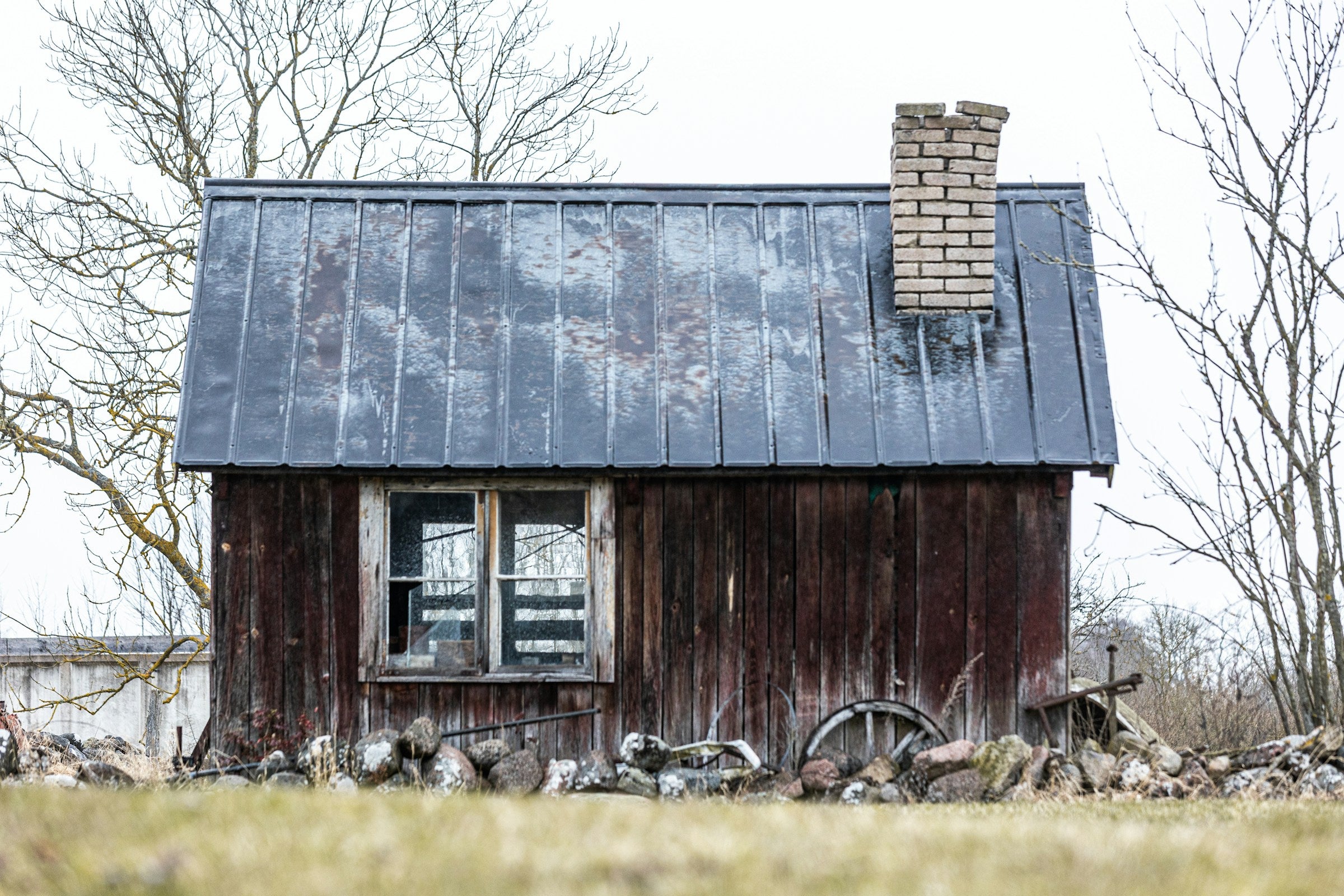 Small wooden cabin with a metal roof in a rural setting